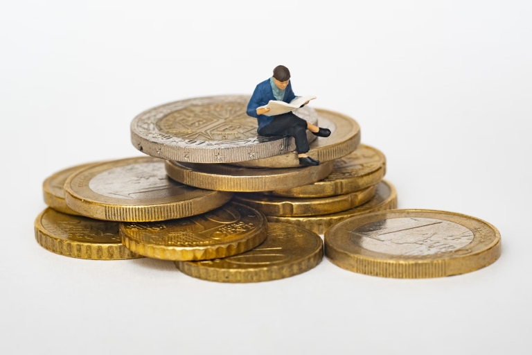 figurka přemýšlí nad financemi na mincích
